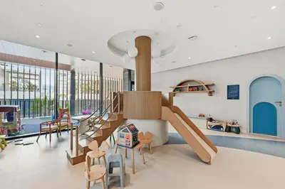 a childrens play room with a slide and chairs at New Cozy Studio, Ideal for 2 in Kensington Waters in Dubai