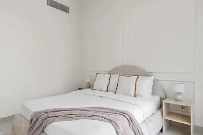 a white bedroom with a bed with a blanket on it at Parkside 2BR plus Maid Canal Front in Dubai