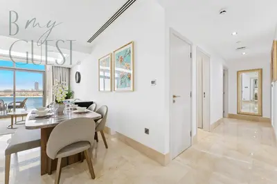 a white dining room with a table and chairs at Stunning Full Sea View 3BR Luxurious Palm Jumeirah in Dubai