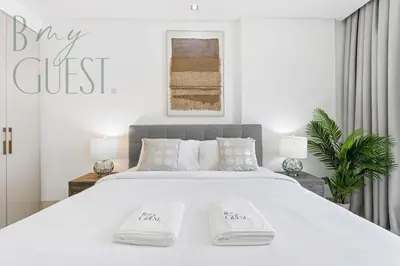 a white bedroom with a large bed with two white pillows at Stunning Full Sea View 3BR Luxurious Palm Jumeirah in Dubai
