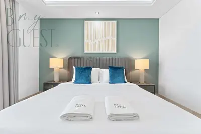 a bedroom with a large white bed with blue pillows at Stunning Full Sea View 3BR Luxurious Palm Jumeirah in Dubai