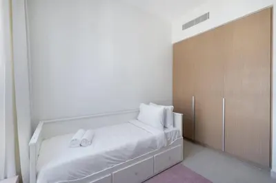 a bedroom with a bed with white sheets and white pillows at StayShort - Dubai Creek Harbour sleeps 6 in a Great Location in Dubai