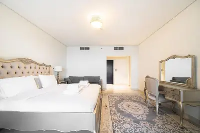 a bedroom with a bed and a mirror and a piano at SettlerHomes - Seaside Lux Escape With Calm Sea View in Dubai