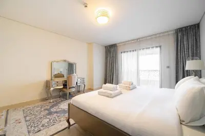 a bedroom with a large white bed and a desk at SettlerHomes - Seaside Lux Escape With Calm Sea View in Dubai