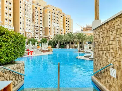a swimming pool in a resort with tall buildings at SettlerHomes - Seaside Lux Escape With Calm Sea View in Dubai