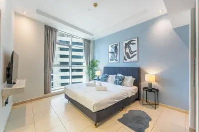 a bedroom with a large bed and a tv at Luxury 3BR Dubai Marina Sea & Ain Dubai View in Dubai