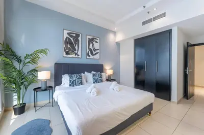 a bedroom with a large white bed with blue walls at Luxury 3BR Dubai Marina Sea & Ain Dubai View in Dubai