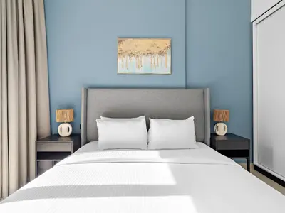 a bedroom with a large bed with blue walls at Classic Luxe 2BDR in Collective in Dubai