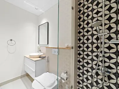 a bathroom with a shower with a toilet and a sink at Classic Luxe 2BDR in Collective in Dubai