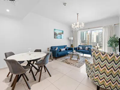 a living room with a table and chairs at 1BR in JLT, Steps from Metro, Marina & Mall in Dubai