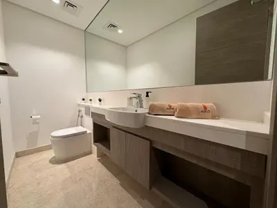 a bathroom with a sink and a toilet and a mirror at Mahenti - Mesmerizing views of The Burj & Downtown Dubai in Dubai