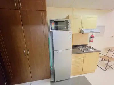 a kitchen with a white refrigerator and a microwave at Mahenti - Elite 1 · Large balcony with all u need in Dubai