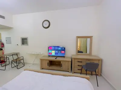 a bedroom with a bed and a tv and a mirror at Mahenti - Elite 1 · Large balcony with all u need in Dubai