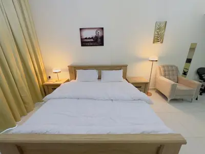a bedroom with a large bed and a chair at Mahenti - Elite 1 · Large balcony with all u need in Dubai
