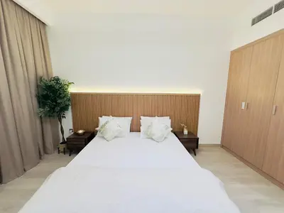 a bedroom with a large bed with white sheets and pillows at Mahenti – Elegant Studio Apartment | Azizi Riviera in Dubai