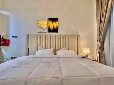 a bedroom with a large white bed in a room at Mahenti - Bright studio near Miracle Garden in Dubai