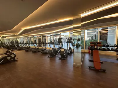 a gym with a lot of treadmills and exercise bikes at Mahenti - Bright studio near Miracle Garden in Dubai