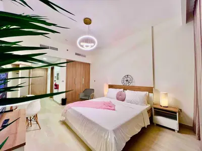 a bedroom with a white bed and a plant at Mahenti - Contemporary Studio Living in Meydan in Dubai