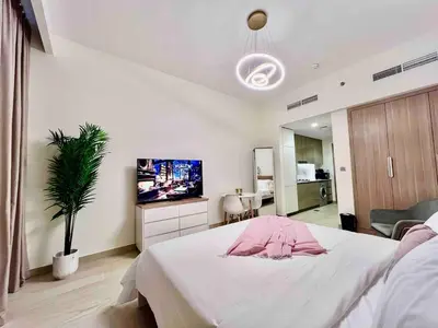 a bedroom with a bed and a flat screen tv at Mahenti - Contemporary Studio Living in Meydan in Dubai