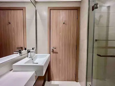 a bathroom with a sink and a wooden door at Mahenti - Contemporary Studio Living in Meydan in Dubai