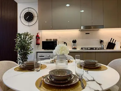 a kitchen with a table with plates and glasses on it at Mahenti- Chic 1BR with Burj & Downtown View in Dubai