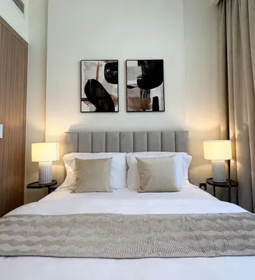 a bedroom with a bed with three pictures on the wall at Mahenti- Chic 1BR with Burj & Downtown View in Dubai