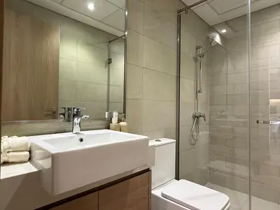 a bathroom with a sink and a toilet and a shower at Mahenti- Chic 1BR with Burj & Downtown View in Dubai