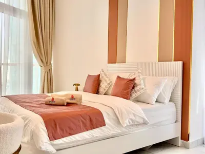 a bedroom with a white bed with orange and white pillows at Mahenti - 1BR - Stunning Lake & Burj Khalifa Views in Dubai