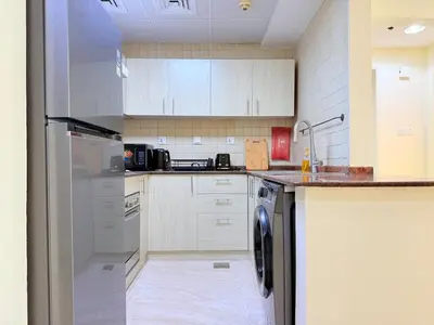 a kitchen with white cabinets and a dishwasher at Mahenti - 1BR in Dubai Marina - Near Metro & Tram in Dubai