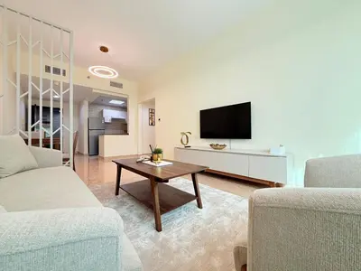 a living room with a couch and a tv at Mahenti - 1BR in Dubai Marina - Near Metro & Tram in Dubai