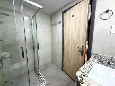 a bathroom with a shower with a glass door at Mahenti - Sunlit Spacious Apartment in JVC in Dubai