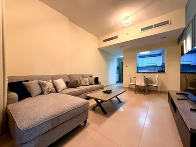 a living room with a couch and a table at Mahenti - Sunlit Spacious Apartment in JVC in Dubai