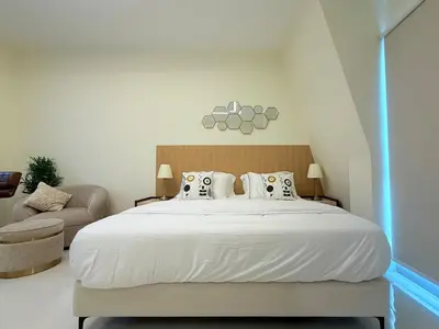 a bedroom with a large white bed and a chair at Mahenti - Bright & Cozy Studio Metro Accessible in Dubai