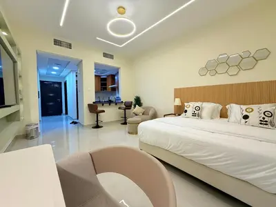 a bedroom with a large bed and a living room at Mahenti - Bright & Cozy Studio Metro Accessible in Dubai
