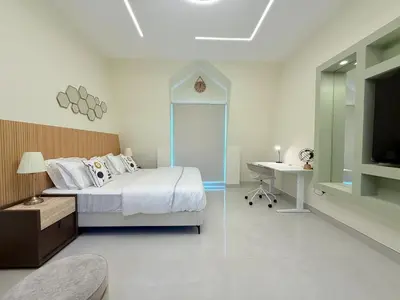 a bedroom with a bed and a desk and a tv at Mahenti - Bright & Cozy Studio Metro Accessible in Dubai