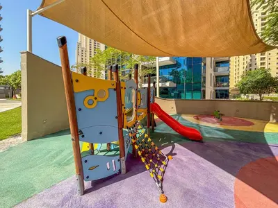 a playground with a slide and a swing at Frank Porter - Aurora Tower, Dubai Marina in Dubai