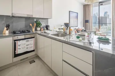 a kitchen with white cabinets and a counter with a sink at Frank Porter - The Paragon in Dubai