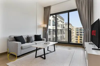 a living room with a couch and a large window at Bookable 1 Bed Liva Tower with Pool & Garden in Dubai