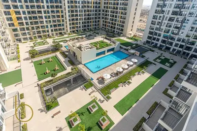 an aerial view of a building with a swimming pool at Bookable 1 Bed Liva Tower with Pool & Garden in Dubai