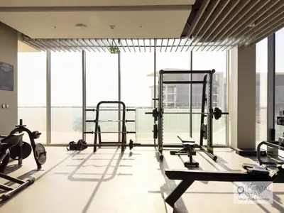 a gym with cardio equipment and large windows at Capital Stay - 1 Bed Apt in MBR City in Dubai