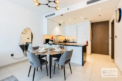 a kitchen and dining room with a table and chairs at Capital Stay - 1 Bed Apt in MBR City in Dubai
