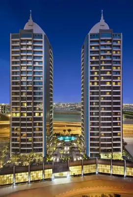two tall buildings in a city at night at Atana Hotel in Dubai