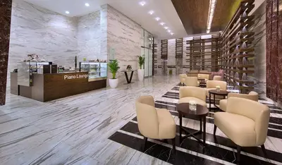 a lobby of a restaurant with tables and chairs at Atana Hotel in Dubai