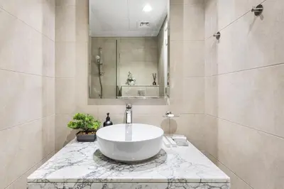 a bathroom with a large white sink on a marble counter at Elegant 1BR Flat in Business Bay with Pool & Gym in Dubai