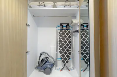 a room with a closet with curtains and a vacuum at Elegant 1BR Flat in Business Bay with Pool & Gym in Dubai