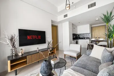 a living room with a tv on a wall at Elegant 1BR Flat in Business Bay with Pool & Gym in Dubai