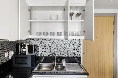 a kitchen with a sink and a microwave at Elegant 1BR Flat in Business Bay with Pool & Gym in Dubai