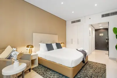 a bedroom with a bed and a couch at DAMAC Maison Cour Jardin - Pool & Gym - Free Parking in Dubai