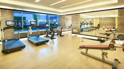 a gym with several cardio machines in a room at DAMAC Maison Cour Jardin - Pool & Gym - Free Parking in Dubai