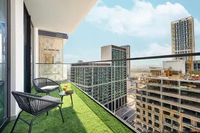 a balcony with a chair and a table at Deluxe Binghatti JVC Suites by Hostiva - City View in Dubai